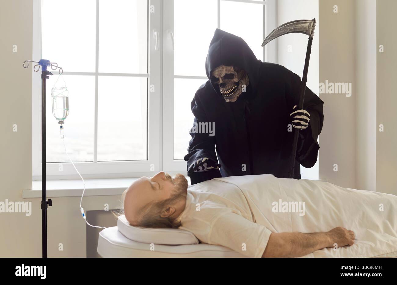 Grim Reaper of Death mit Sense findet neues Opfer im Krankenhaus, Klinikstation, Patientencouch sterbend Stockfoto