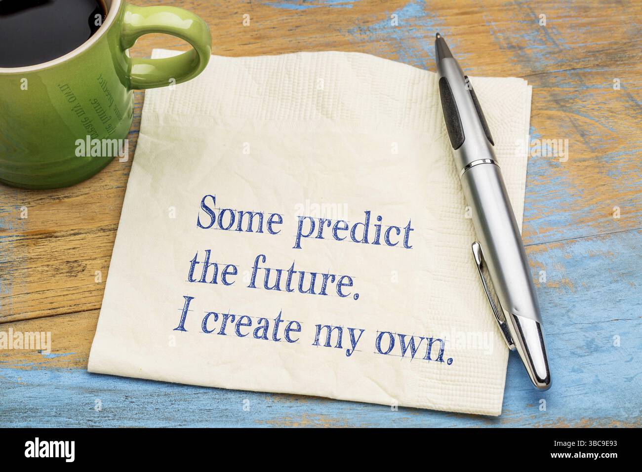 Einige sagen die Zukunft voraus. Erstelle ich meine eigene. Motivierende Handschrift auf einer Serviette mit einer Tasse Kaffee Stockfoto