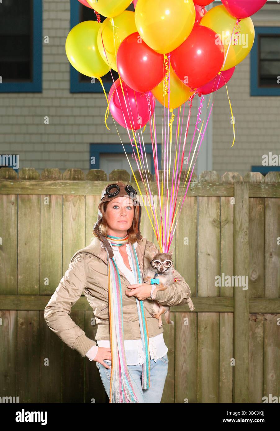 Frau und Hund mit Ballons für den Flug gekleidet. Stockfoto