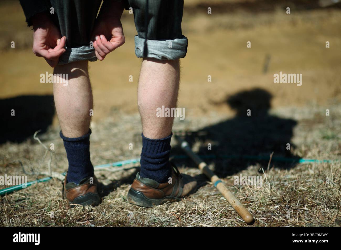 Bauern, die im Schlamm graben, um Reisfelder zu kreieren. Stockfoto