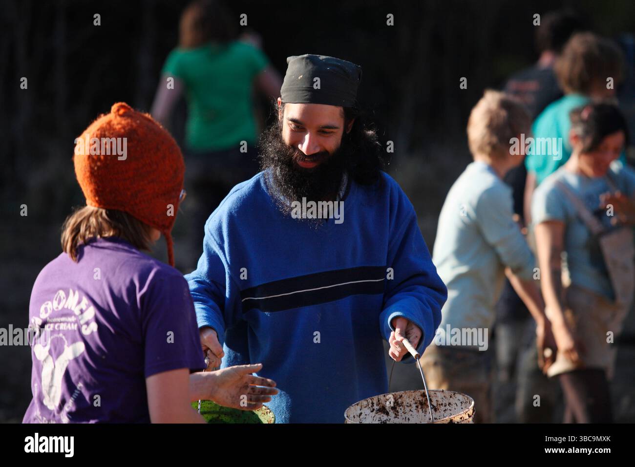 Bauern, die im Schlamm graben, um Reisfelder zu kreieren. Stockfoto
