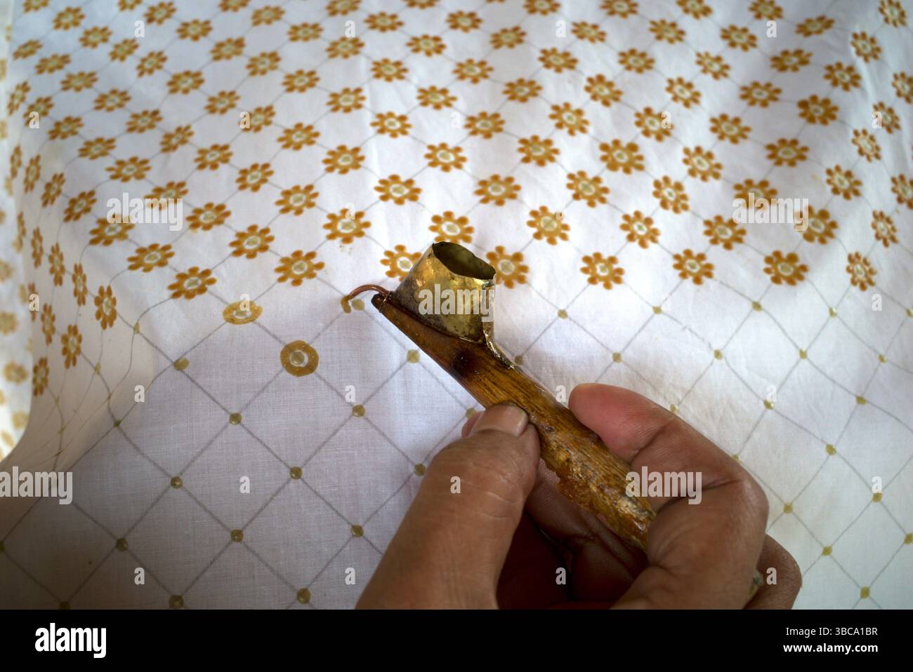 Bei der Herstellung von Batik, einer traditionellen indonesischen Kleidung, werden Linien und Punkte auf dem Stoff durch Canting hergestellt. Stockfoto