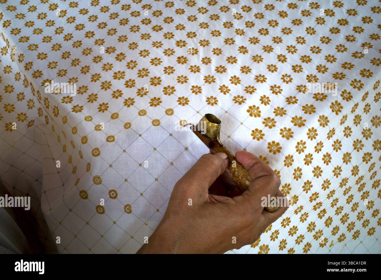 Bei der Herstellung von Batik, einer traditionellen indonesischen Kleidung, werden Linien und Punkte auf dem Stoff durch Canting hergestellt. Stockfoto