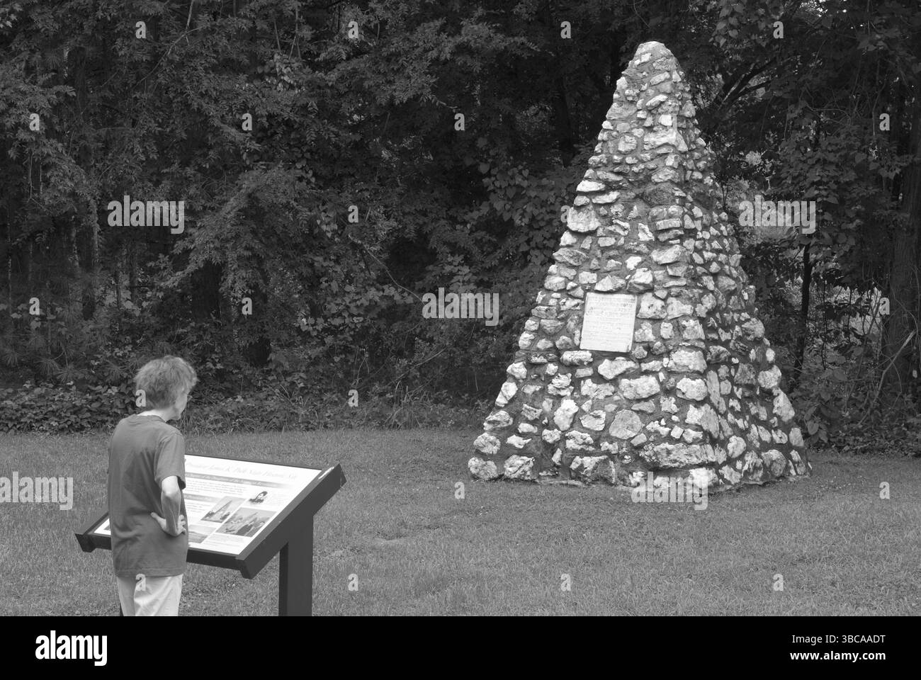 Eine kaukasische Frau liest einen Gedenkmarker auf dem ursprünglichen Gehöft von Präsident James K. Polk in der Nähe von Charlotte, North Carolina, USA. Stockfoto