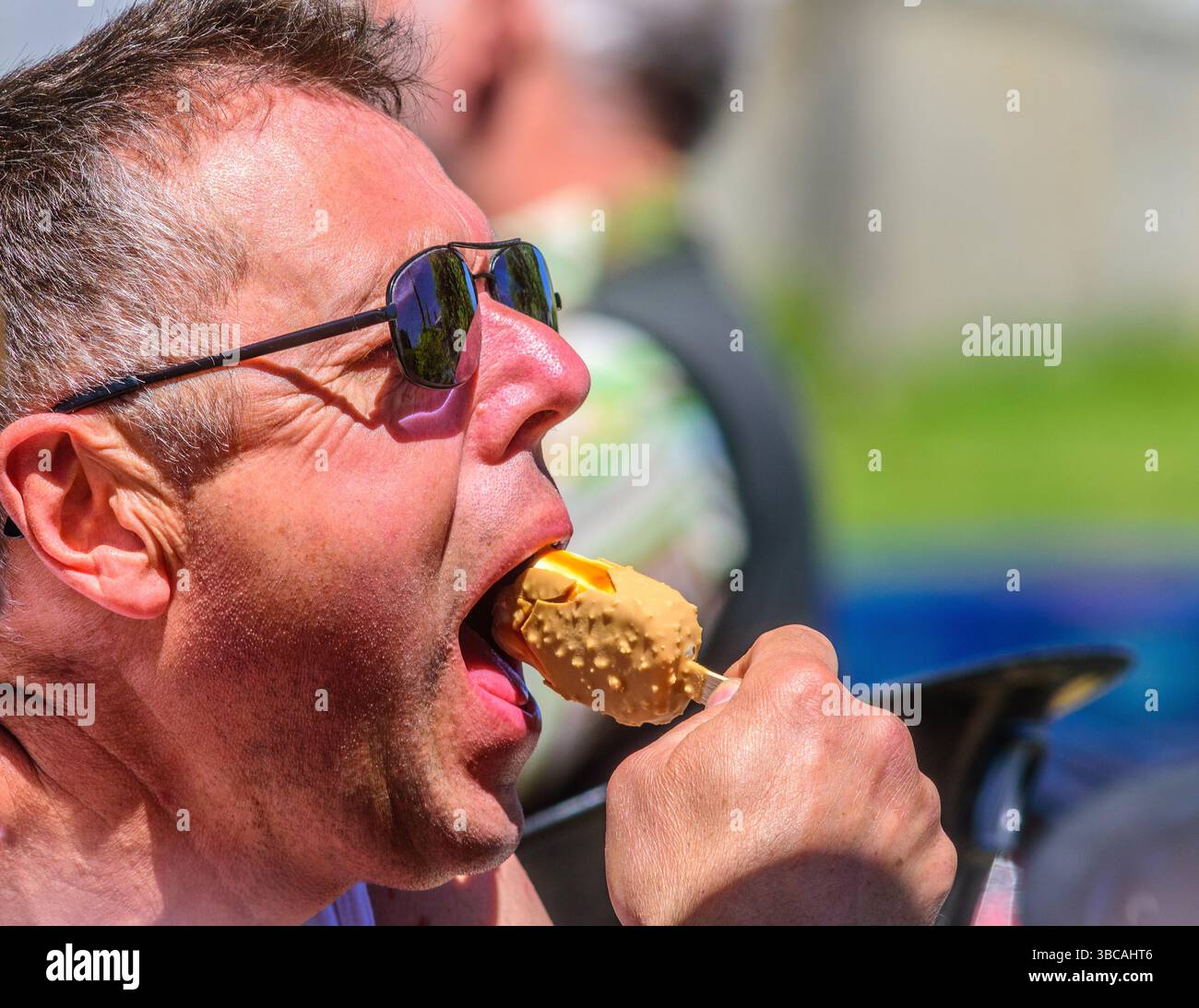 Mann, der an einem heißen Tag kühl hält und ein Magnum-Eis isst - Preuilly-sur-Claise (37), Frankreich. Stockfoto