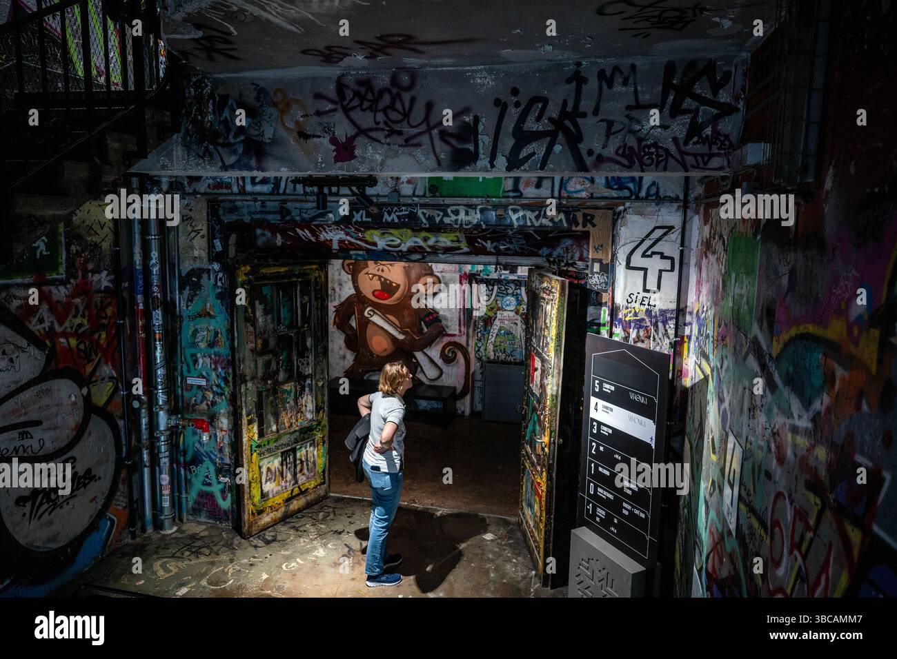 Ein Besucher erkundet das mit Graffiti bedeckte Innere der Fotografiska Berlin, die sich im historischen Tacheles-Gebäude befindet, das als Fotografiemuseum wiedereröffnet wurde. Stockfoto