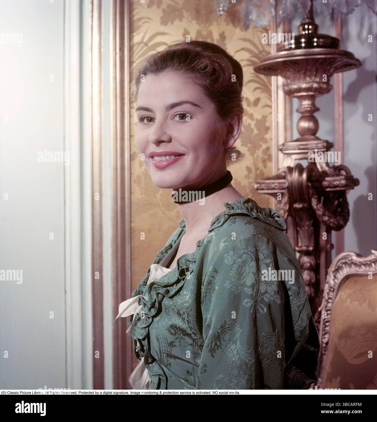 Wie im 18. Jahrhundert. Maj-Britt Nilsson (1924–2006) in einem Fotoshooting im Schloss Drottningholm für einen Roman über Magdalena Rudenschöld von Ole Söderström. Das Foto wurde ursprünglich veröffentlicht, um einen historischen Roman zu illustrieren, der in mehreren Episoden in einer Zeitschrift 1956 läuft. Das Zimmer, die Möbel und die Kleidung sind originell und typisch für das Schweden des 18. Jahrhunderts. Maj-Britt Nilsson als Magdalena Rudenschöld spielt die Geschichte im 18. Jahrhundert. Conard Ref. 3168. Stockfoto