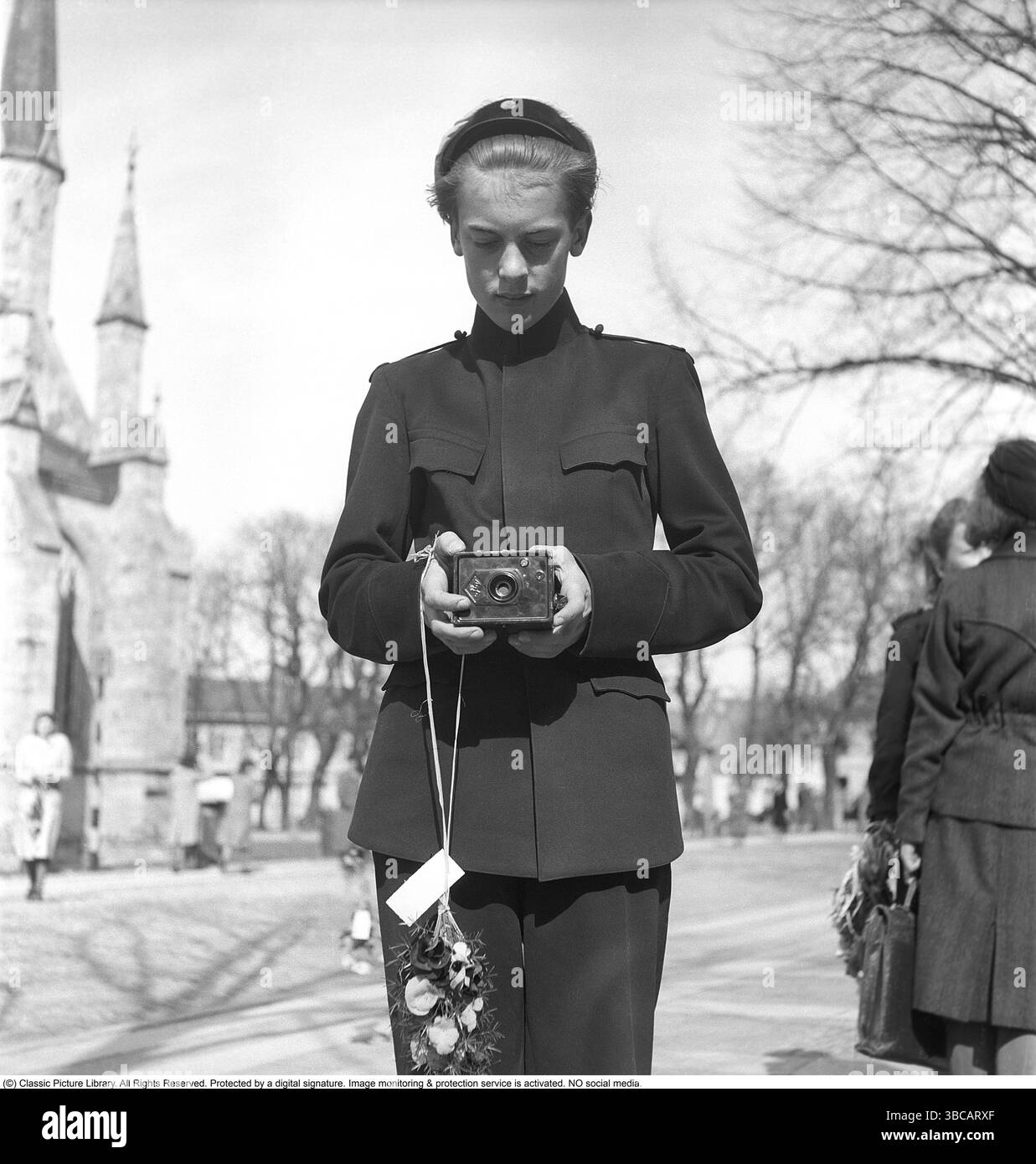 Schüler mit Kamera. Nach erfolgreichem Abschluss seiner Hochschulausbildung ist er für den großen Tag gekleidet, an dem die Abschlussfeier gefeiert wird. Er selbst benutzt eine Agfa-Kamera, um Fotos zu machen. 1947. Kristoffersson Ref. AF32-6 Stockfoto