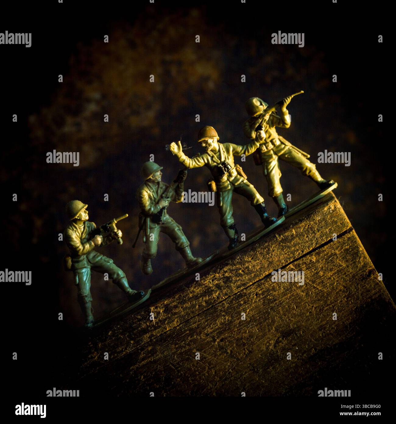 Eine Gruppe von Spielzeugsoldaten wird in Bewegung gefangen, während sie eine steile Steigung überwinden und dabei Teamwork und Strategie zeigen. Stockfoto