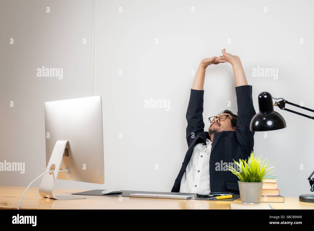 Stretching am Arbeitsplatz, das für das körperliche und geistige Wohlbefinden während langer Arbeitszeiten unerlässlich ist Stockfoto