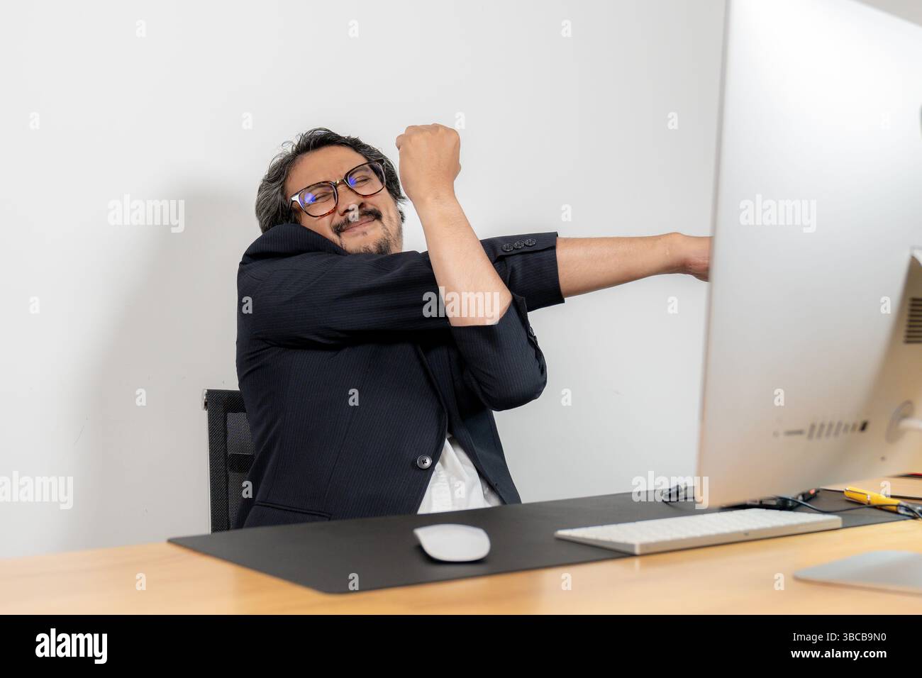 Stretching am Arbeitsplatz, das für das körperliche und geistige Wohlbefinden während langer Arbeitszeiten unerlässlich ist Stockfoto