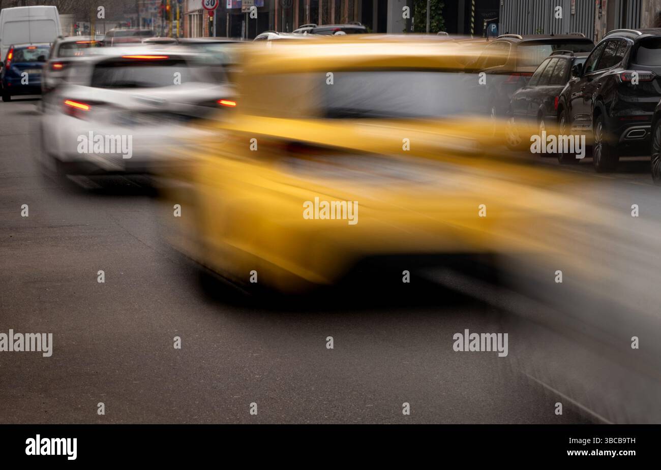 Gelbes Taxi beschleunigt durch den Stadtverkehr und erzeugt einen Bewegungsunschärfeeffekt Stockfoto