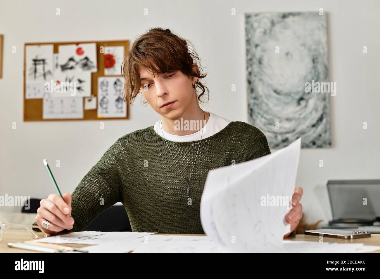 Fokussierte junge Schüler arbeiten zu Hause an seinem Kunstwerk, umgeben von Skizzen und kreativen Materialien. Stockfoto