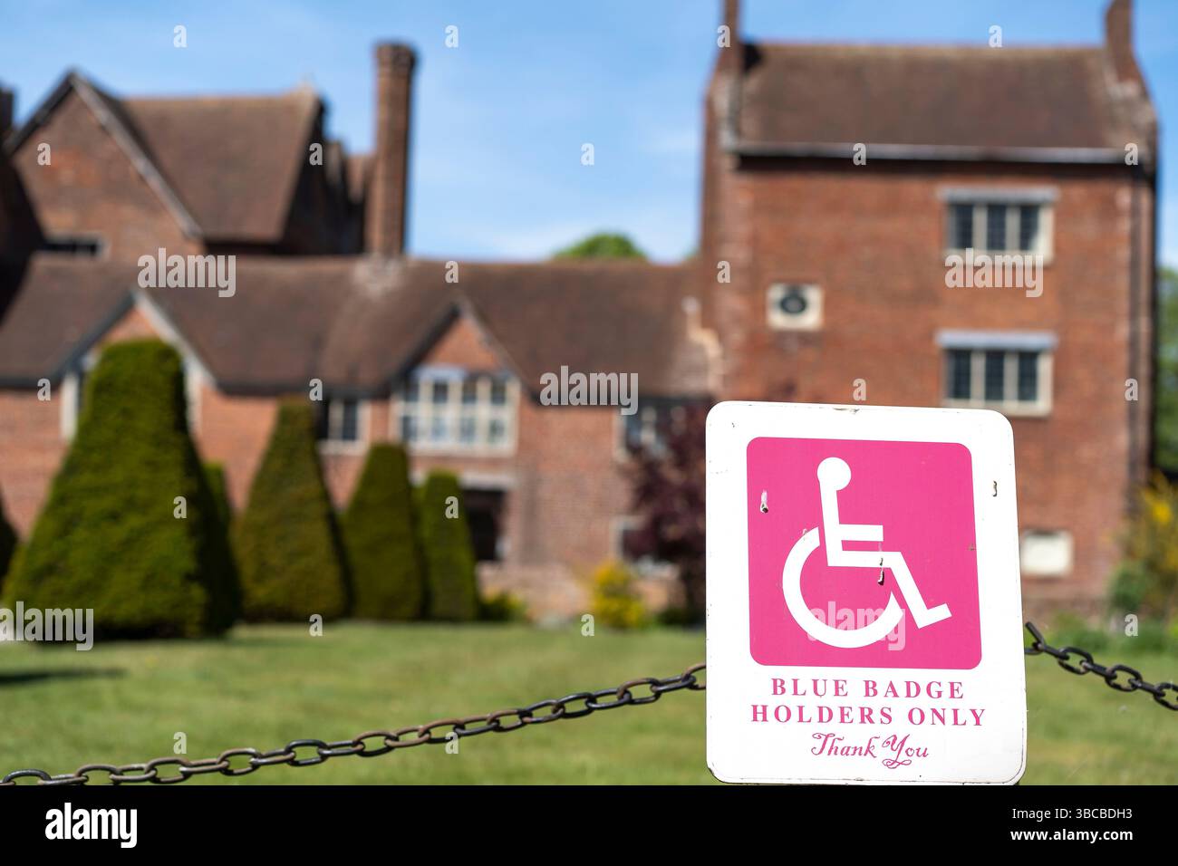 Nahaufnahme eines blauen Schild mit Parkplatzhalter vor einem großen alten Anwesen und Touristenattraktion. Auf dem Schild steht auch ein Dankeschön Stockfoto