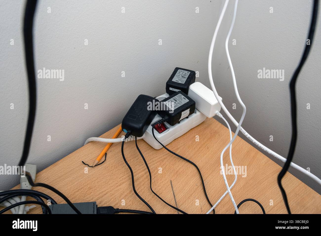 Ein staubiges elektrisches Verlängerungskabel voller Netzstecker kann eine Brandgefahr darstellen. Stockfoto