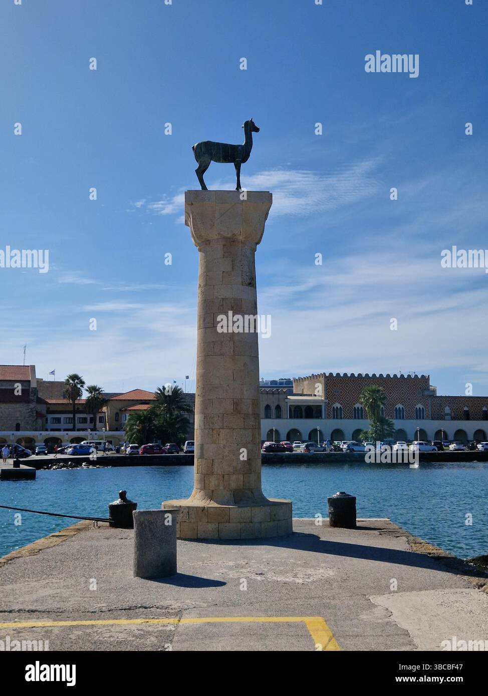 Säulendenkmal mit Hirschstatue am Ufer unter klarem Himmel. Rhodos, Rhodos Stadt, Griechenland Stockfoto