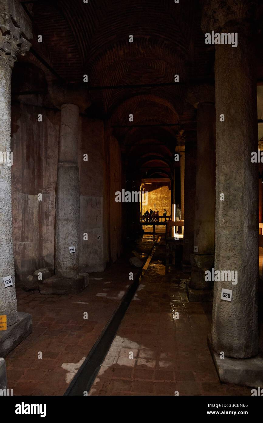 Antike Basilika-Zisterne, Istanbul. Schwach beleuchtete Passage mit Steinsäulen, Bogendecken und Touristenweg Stockfoto