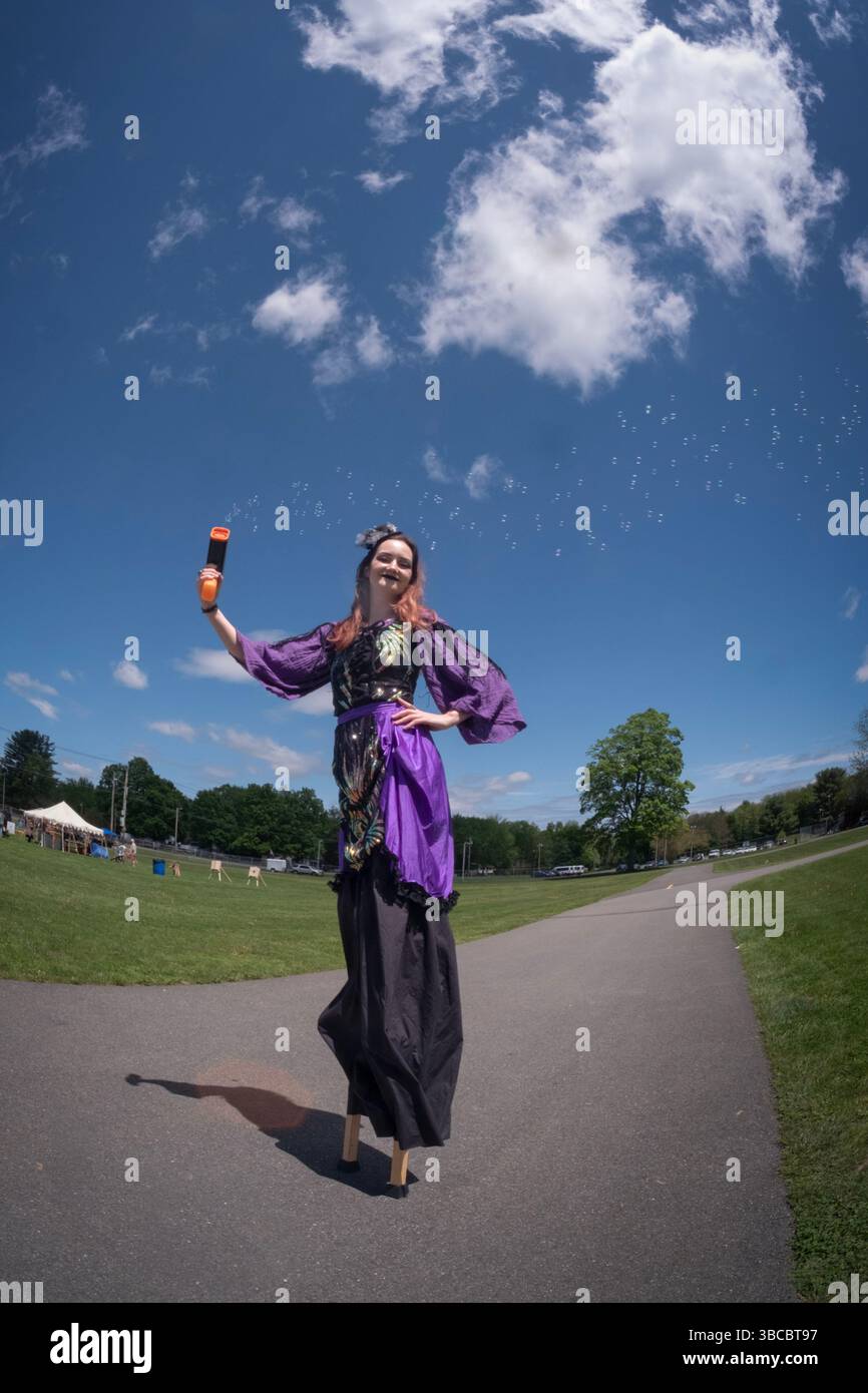 Eine junge Dame auf Stelzen schießt beim Piratenfestival in New Paltz, New York, kleine Blasen aus ihrer Wasserpistole. Stockfoto