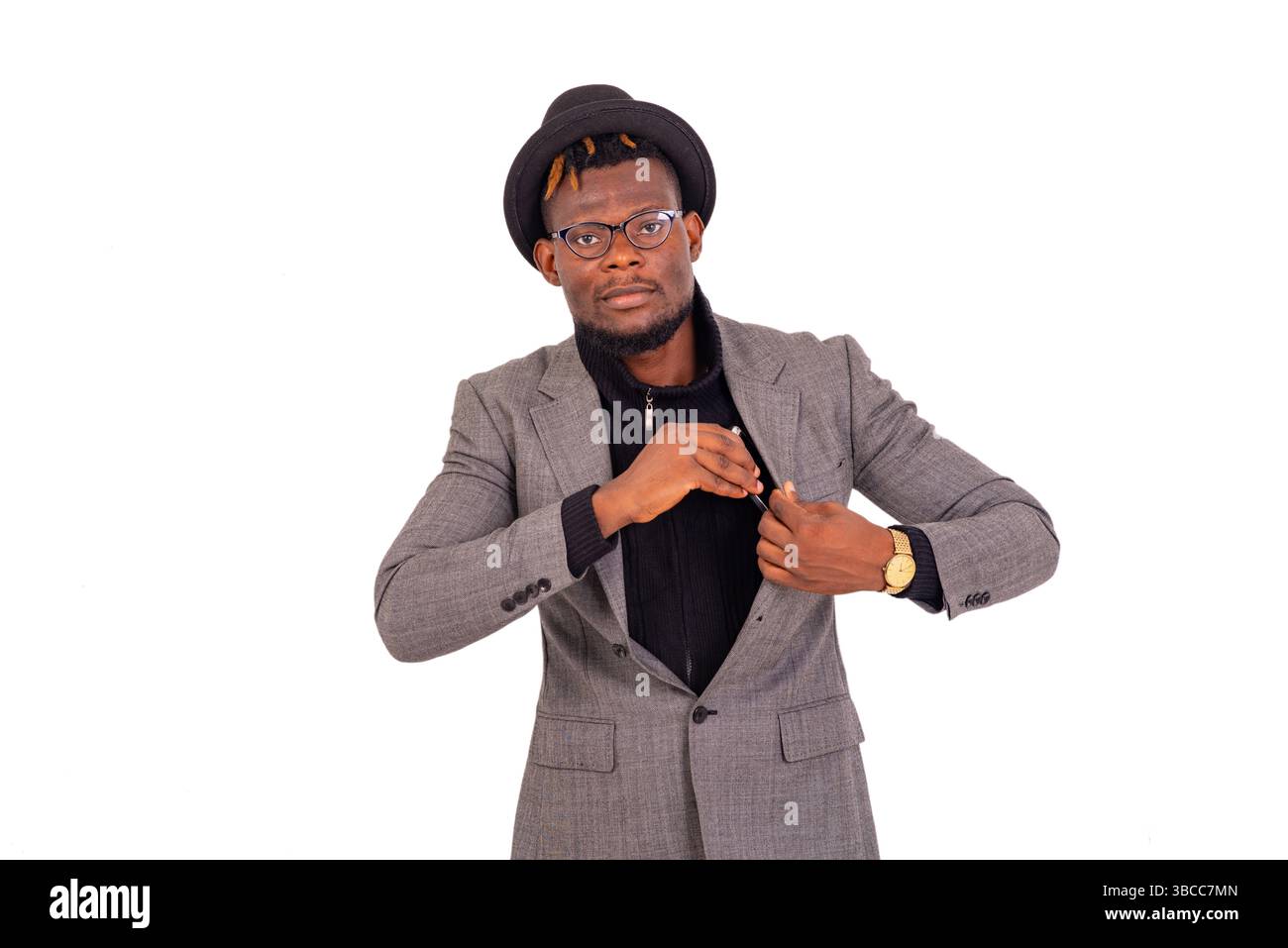 Hübscher junger Geschäftsmann in elegantem Anzug und nimmt oder steckt ein Handy in die Jackentasche. Stockfoto