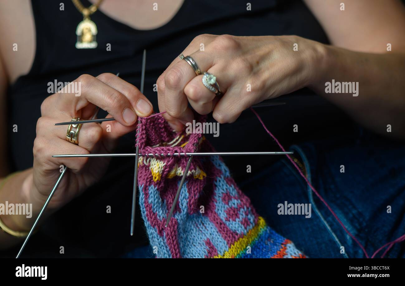 Nahaufnahme einer Frau, die von Hand gemusterte Socken strickt Stockfoto