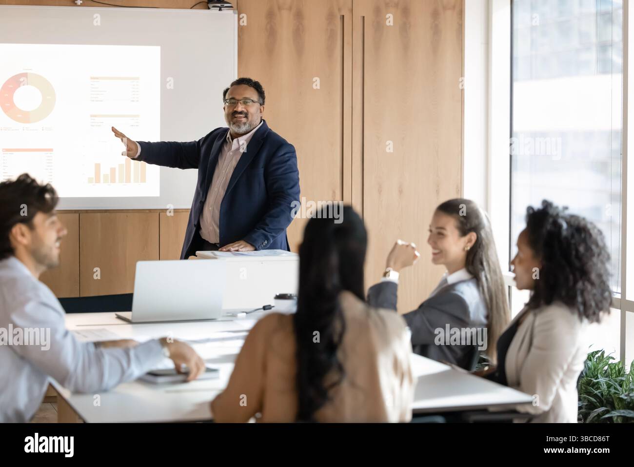 Selbstbewusster indischer Geschäftsmann führt Präsentation im modernen Konferenzraum Stockfoto