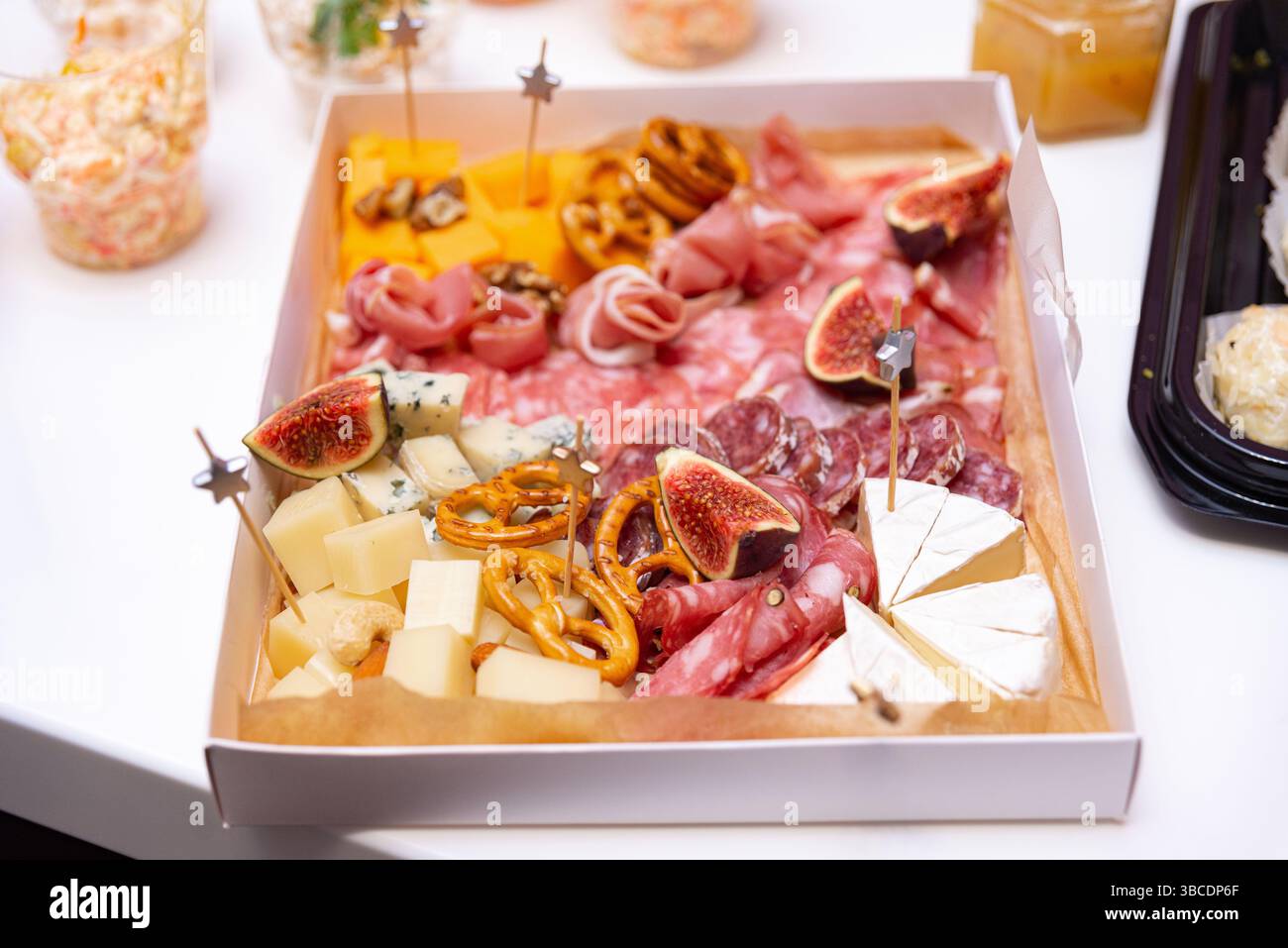 Eine Gourmet-Wurstplatte mit verschiedenen Käsesorten, Wurstwaren, Feigen, Brezeln und Nüssen, perfekt für Partys oder gehobenes Catering. Stockfoto