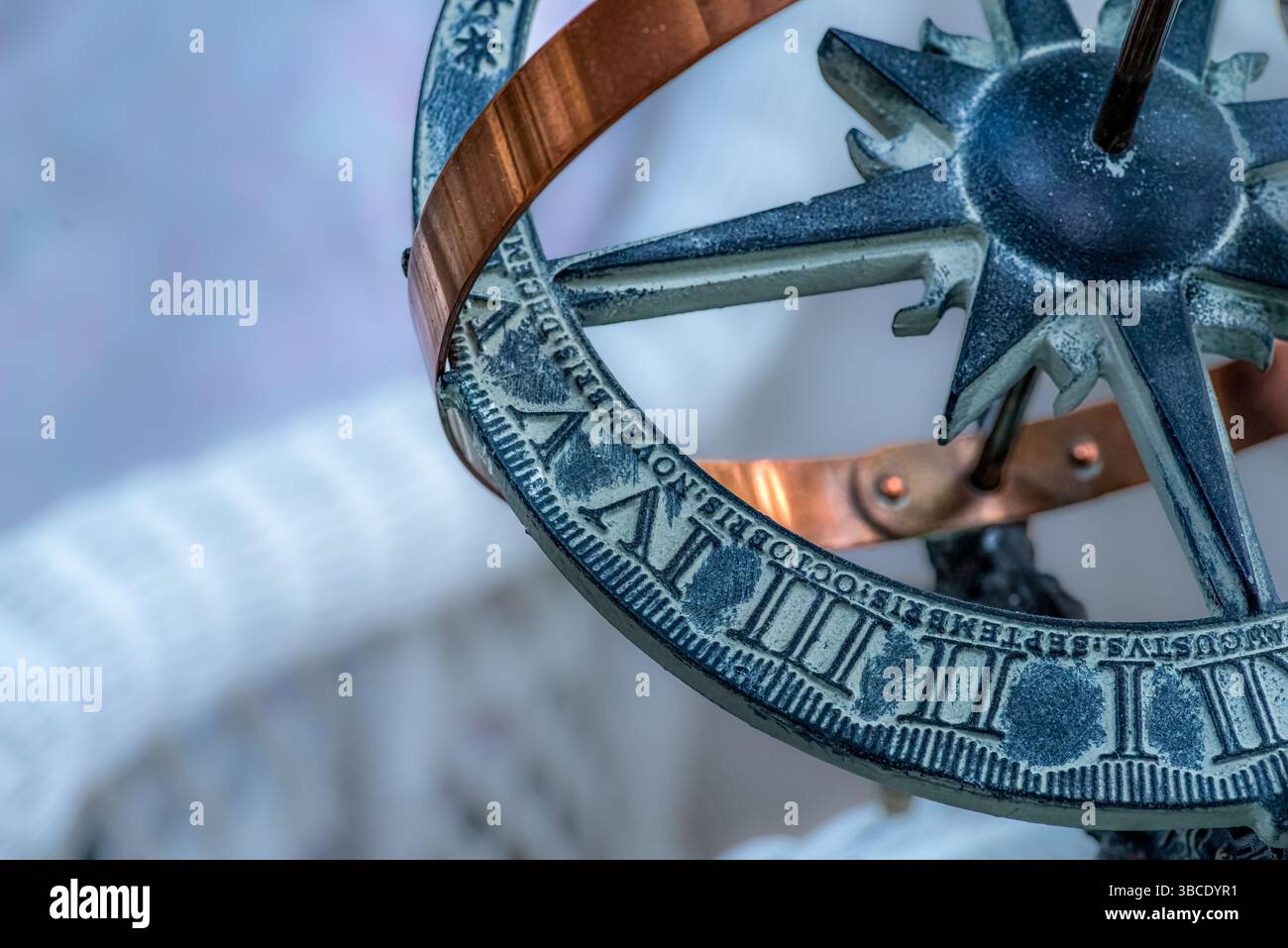Nahaufnahme einer dekorativen Armillarkugel oder Sonnenuhr mit römischen Ziffern, Kupferband und Kompassdesign in natürlichem Licht. Stockfoto