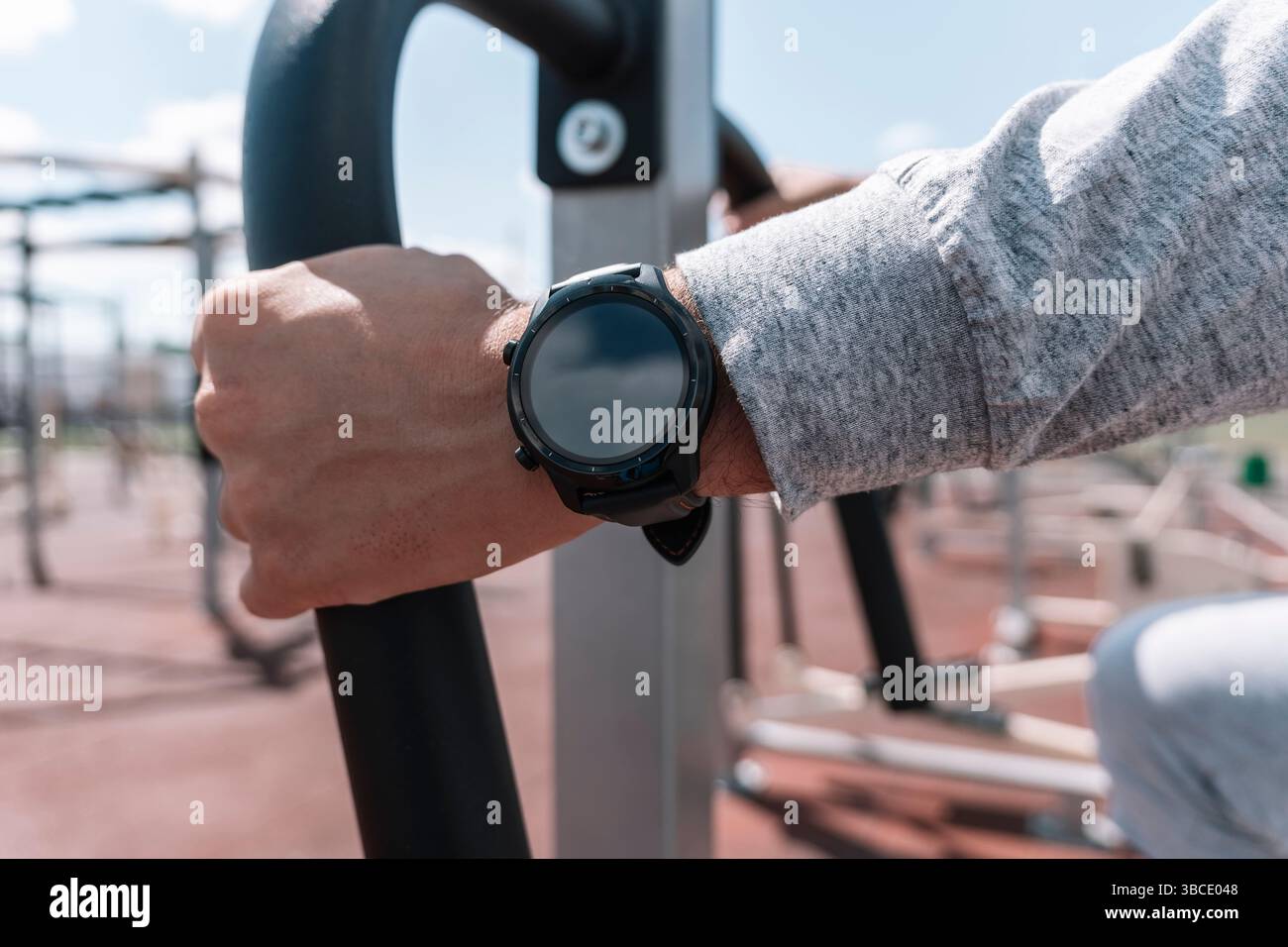 Smartwatch am Körper tragbares Smart Tech Fitness aktiv Sportler Haupt verwendet Sportuhr beim Training Kardio-Workout seine Herzfrequenz prüfen. Stadtstadion. Stockfoto
