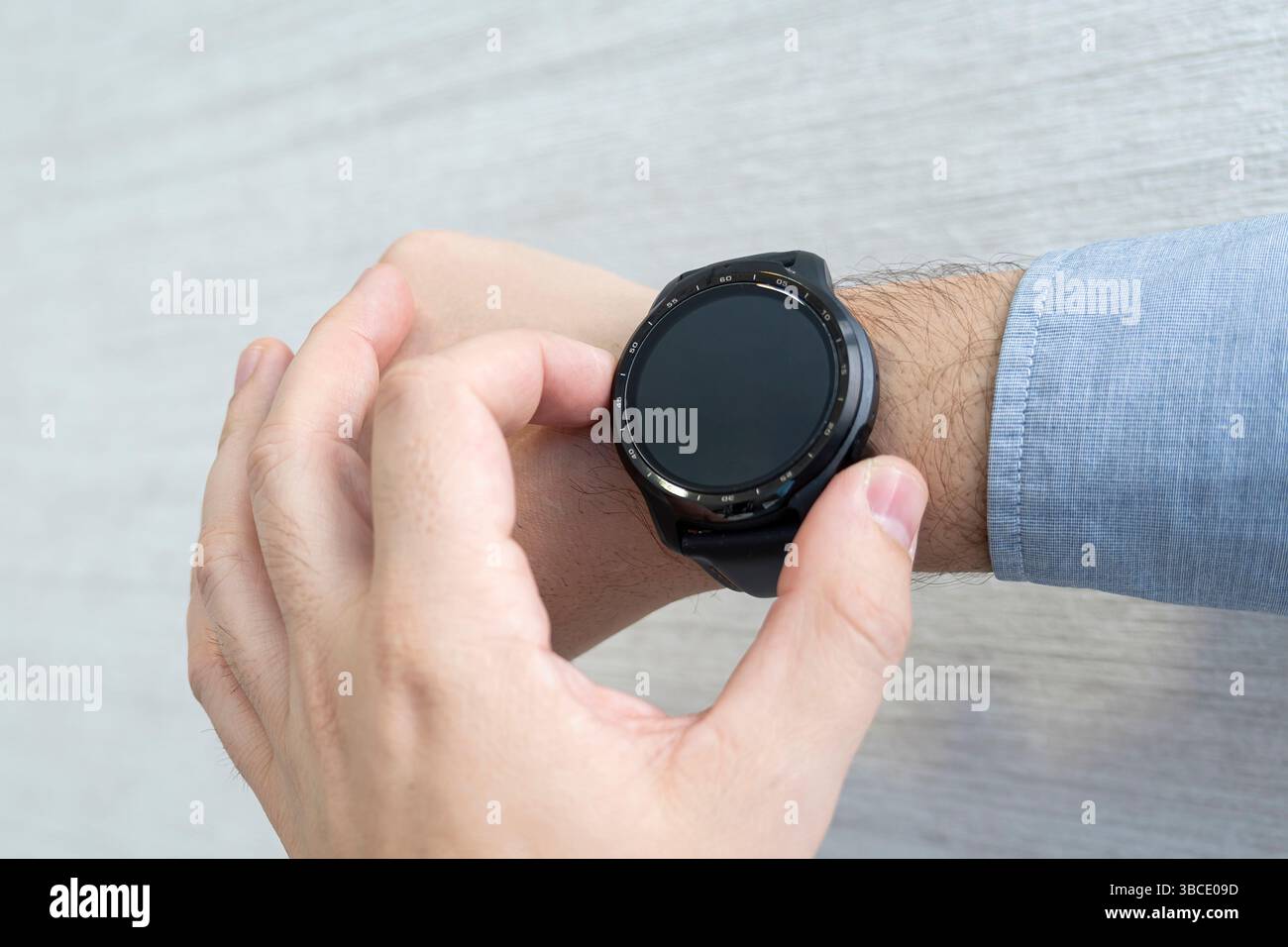 Der Mann drückt seinen Finger auf den Bildschirm seiner Smartwatch. Draufsicht Stockfoto
