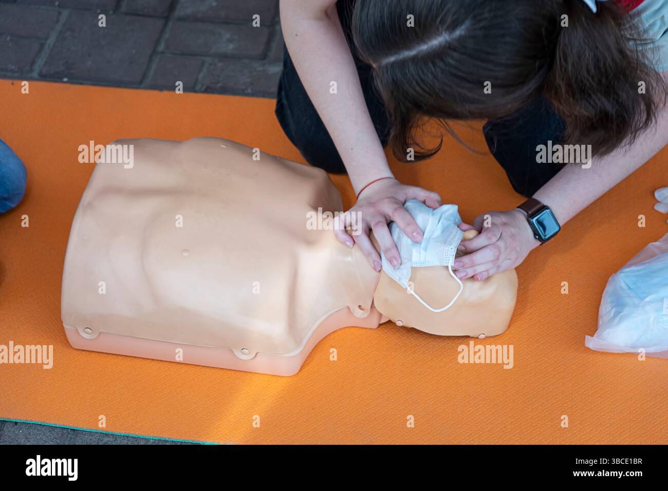 Frau, die HLW an einer Schaufensterpuppe zum Training durchführt. Direkte Herzmassage. Erste-Hilfe-Training an einer medizinischen Dummy. Stockfoto