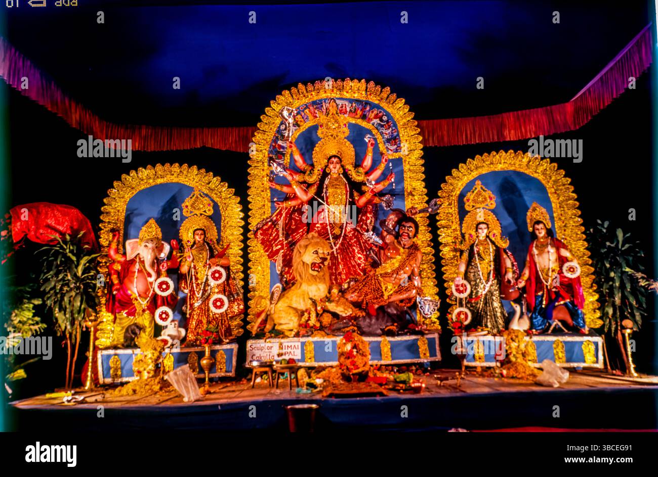 Durga Puja feiert den Sieg der Göttin Durga über den Dämonenkönig Mahishasura. Es beginnt am selben Tag wie Navratri, ein neuntägiges Fest in vielen nördlichen und westlichen Staaten, das im weiteren Sinne das göttliche Weibliche (shakti) feiert. Durga Puja, auch bekannt als Durgotsava oder Sharodotsava, ist ein alljährliches Hindu-Fest, das auf dem indischen Subkontinent seinen Ursprung hat und der Hindu-Göttin Durga huldigt Stockfoto Durga Puja feiert den Sieg der Göttin Durga über den Dämonenkönig Mahishasura. Es beginnt am selben Tag wie Navratri, ein neuntägiges Fest in vielen nördlichen und westlichen Staaten, das im weiteren Sinne das göttliche Weibliche (shakti) feiert. Durga Puja, auch bekannt als Durgotsava oder Sharodotsava, ist ein alljährliches Hindu-Fest, das auf dem indischen Subkontinent seinen Ursprung hat und der Hindu-Göttin Durga huldigt Stockfoto