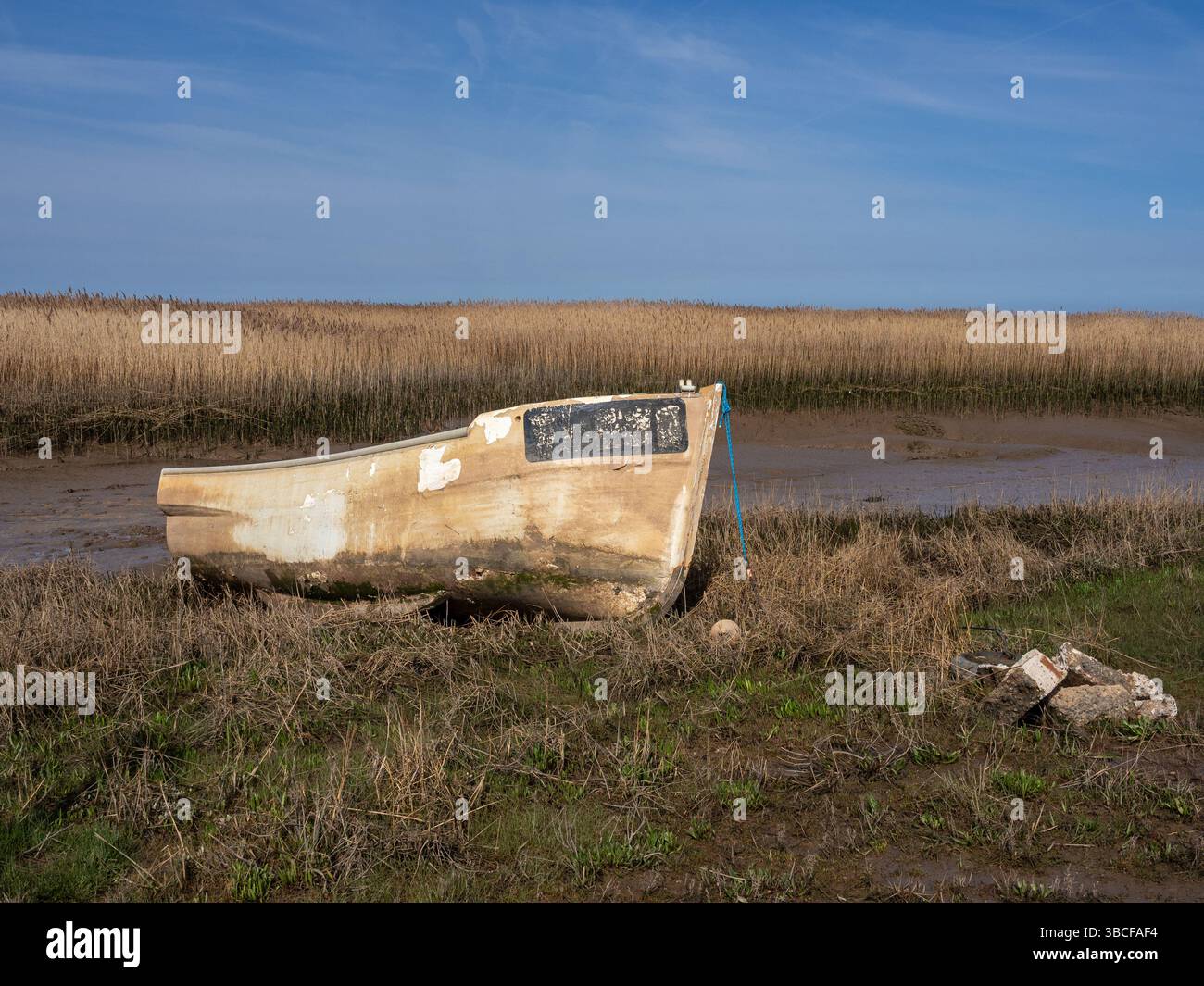 Ein ruchloses Fischerboot auf den Gezeitensümpfen in Brancaster Staithe, Norfolk, Großbritannien Stockfoto