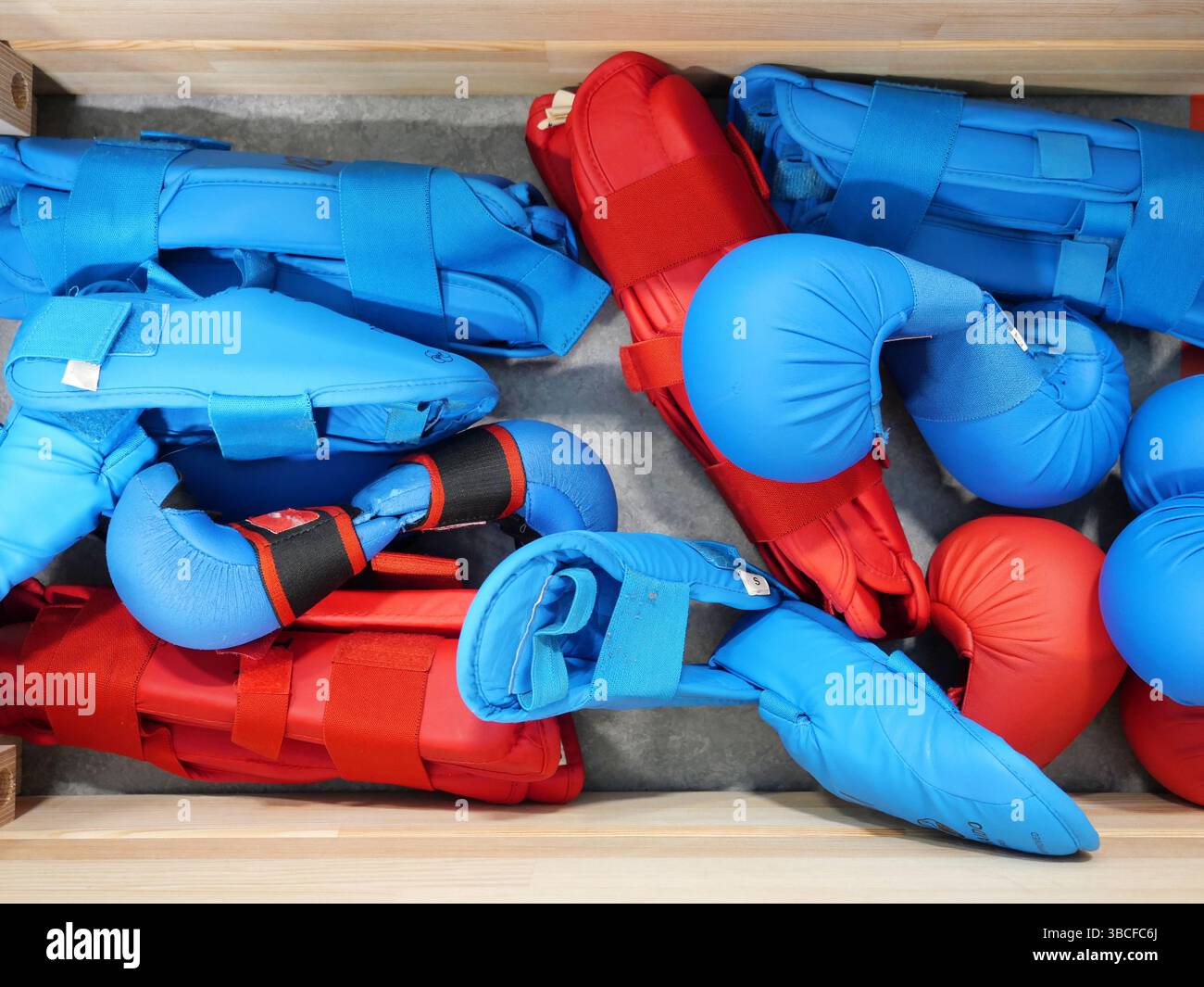 Box mit Protektoren bereit für Karate-Wettkämpfe – Kinder, Jugendliche und Senioren aus verschiedenen Clubs treffen sich mit Fokus, Respekt und Teamgeist. Leerzeichen für Text Stockfoto
