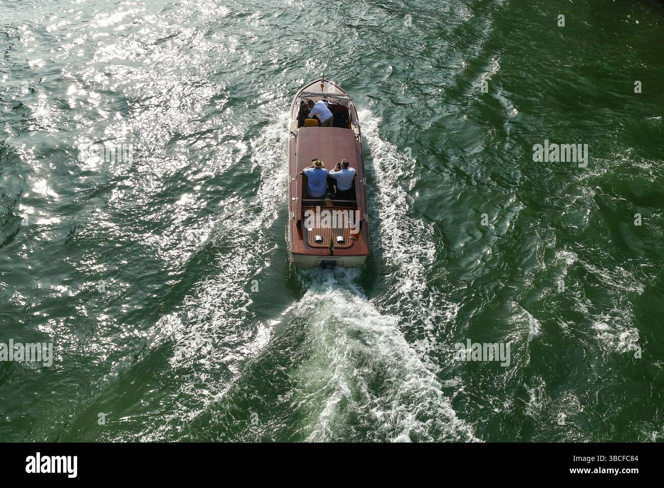 Aus der Vogelperspektive eines luxuriösen Wassertaxis auf dem Canal Grande, mit drei Männern an Bord im Sommer, Venedig, Venetien, Italien Stockfoto