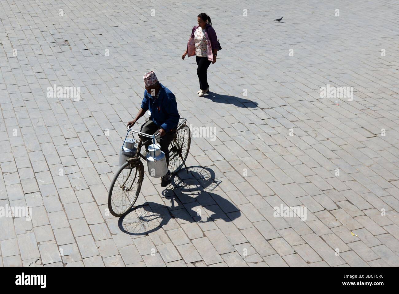 Ein nepalesischer Mann radelt durch den Dattatraya-Platz in der Altstadt von Bhaktapur, Nepal. Stockfoto