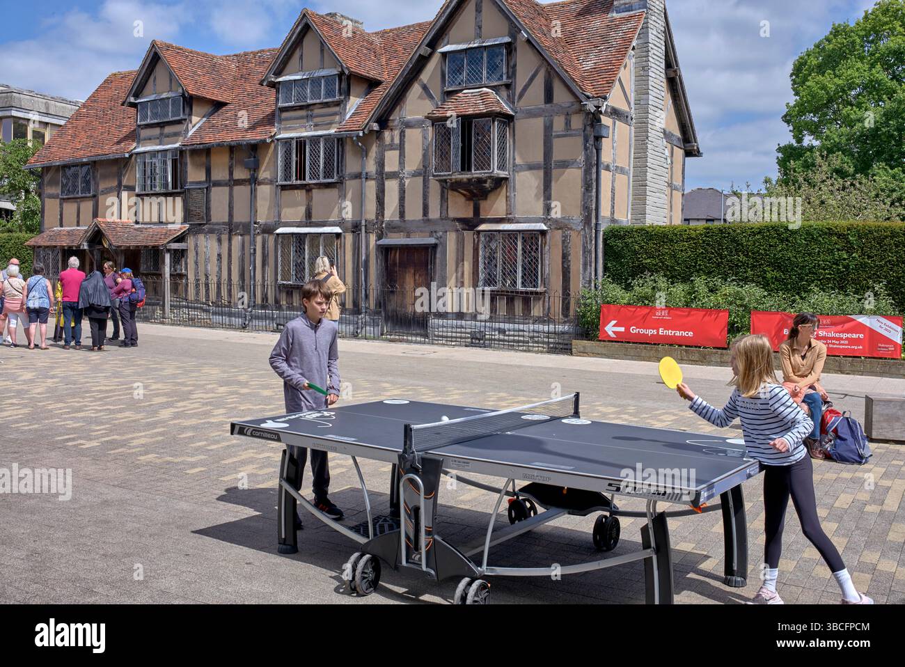 Kinder spielen Tischtennis vor dem Hintergrund des Geburtshauses von William Shakespeare. Henley Street, Stratford upon Avon, England, Großbritannien Stockfoto