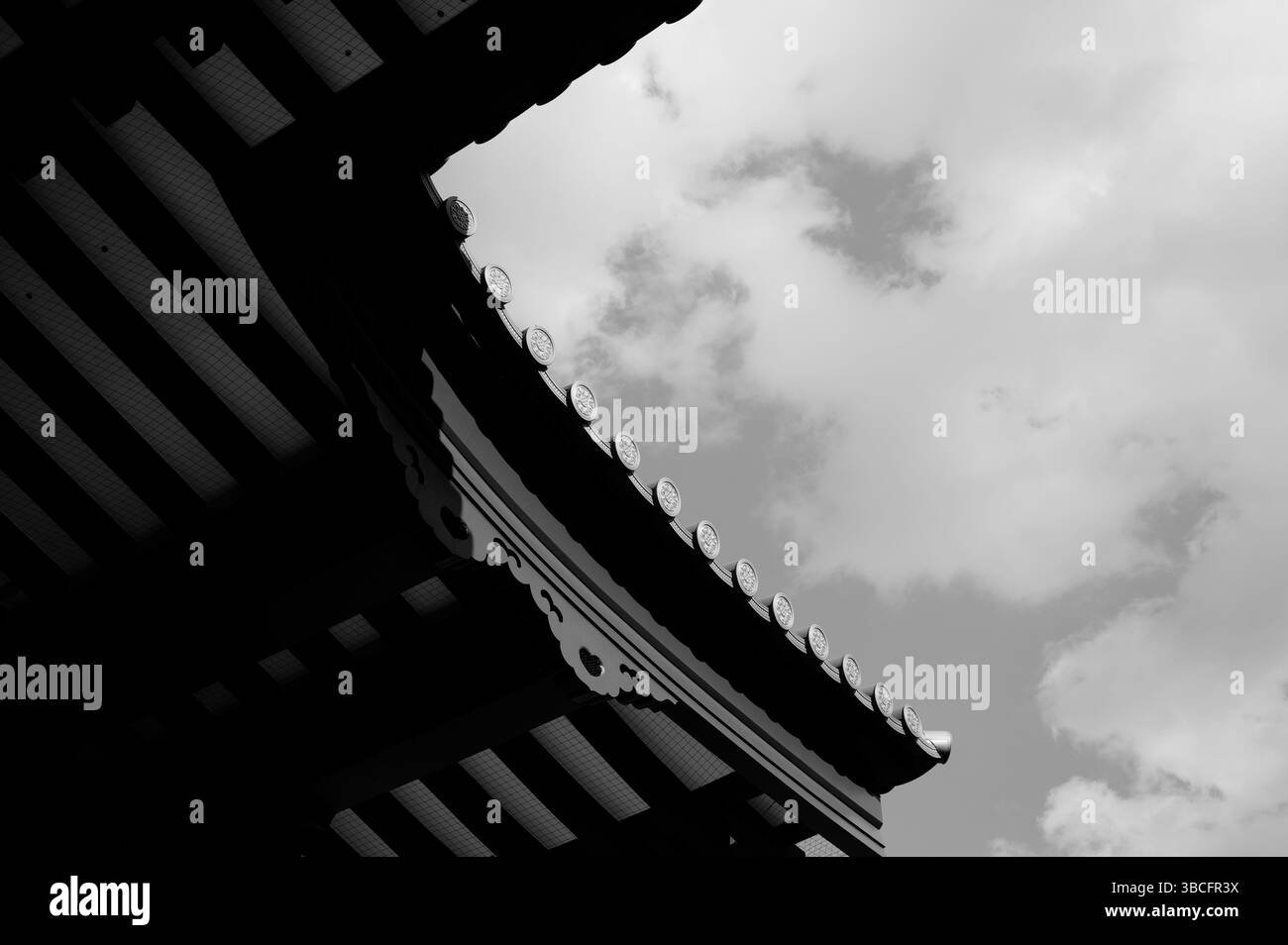 Die Dachlinie der Haupthalle von Zōjō-JI schneidet sich in Schwarz-weiß scharf in den bewölkten Himmel ein Stockfoto