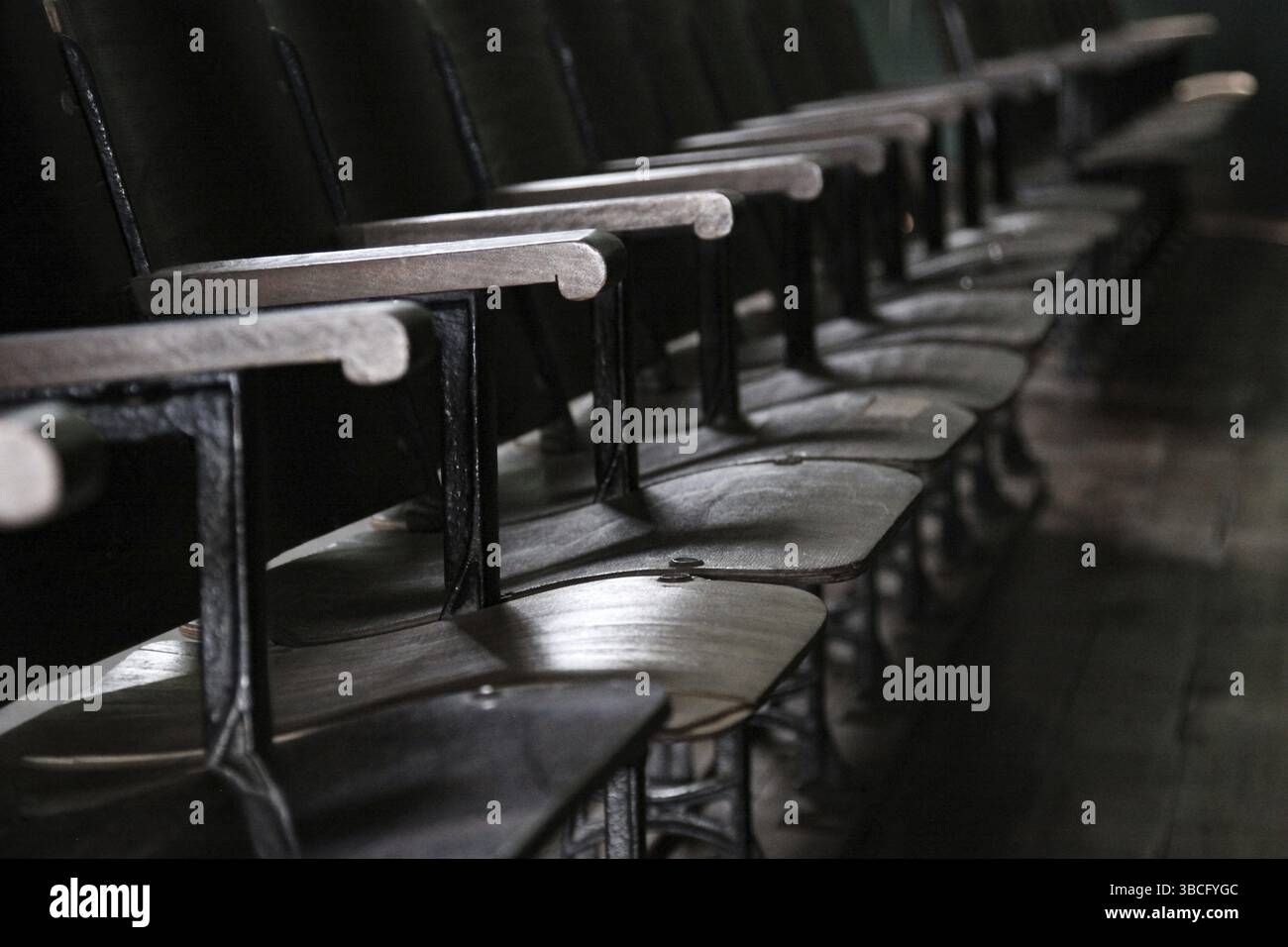 Alte schwarze Stühle in einer Reihe im Theater Stockfoto