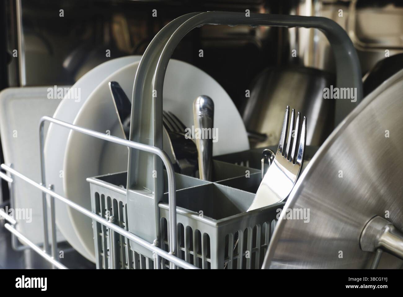 Teller, Gabeln, Messer, Tassen im Geschirrspüler Stockfoto