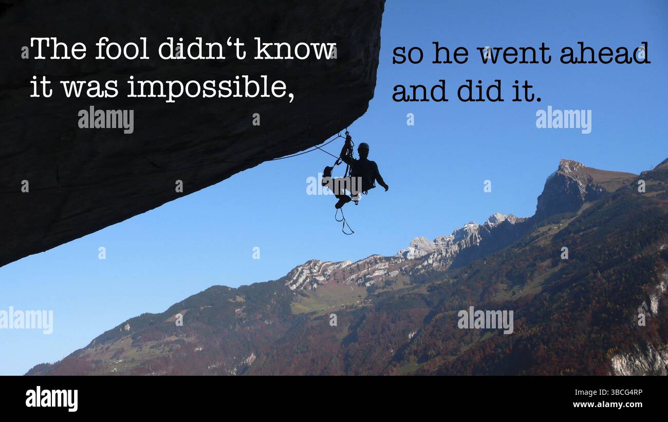 Ein Kletterer hängt von einem überhängenden Dach mit einer tollen Aussicht und inspirierendem Text Stockfoto