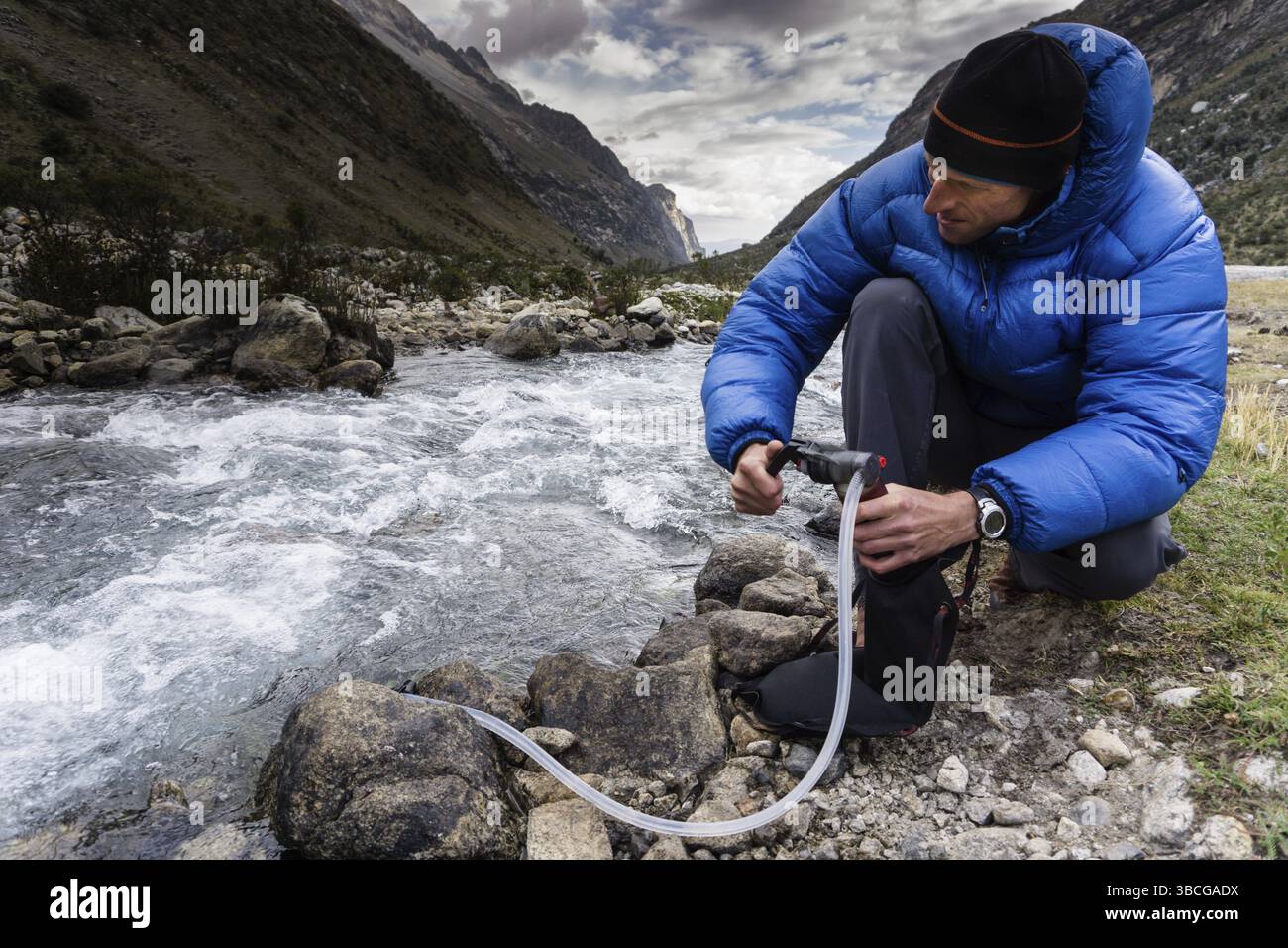 Bergsteiger filtrieren und pumpen Trinkwasser aus einem Bach in einem abgelegenen Tal in der Cordillera Blanca in den Anden in Peru Stockfoto
