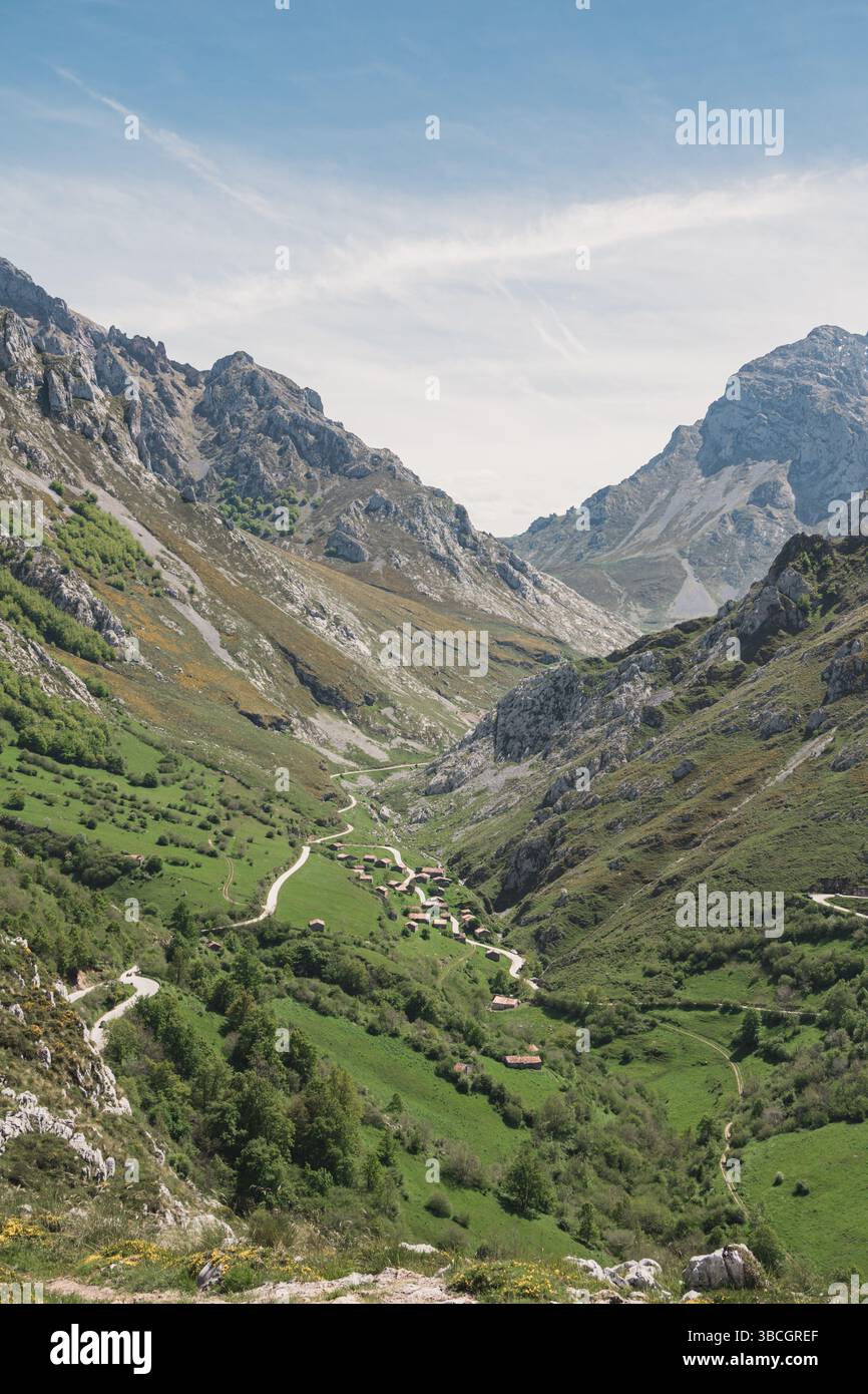Vertikale Perspektive vom Aussichtspunkt Sotres mit Blick auf ein verstecktes Dorf in einem grünen Tal der Picos de Europa, Asturien, Spanien Stockfoto