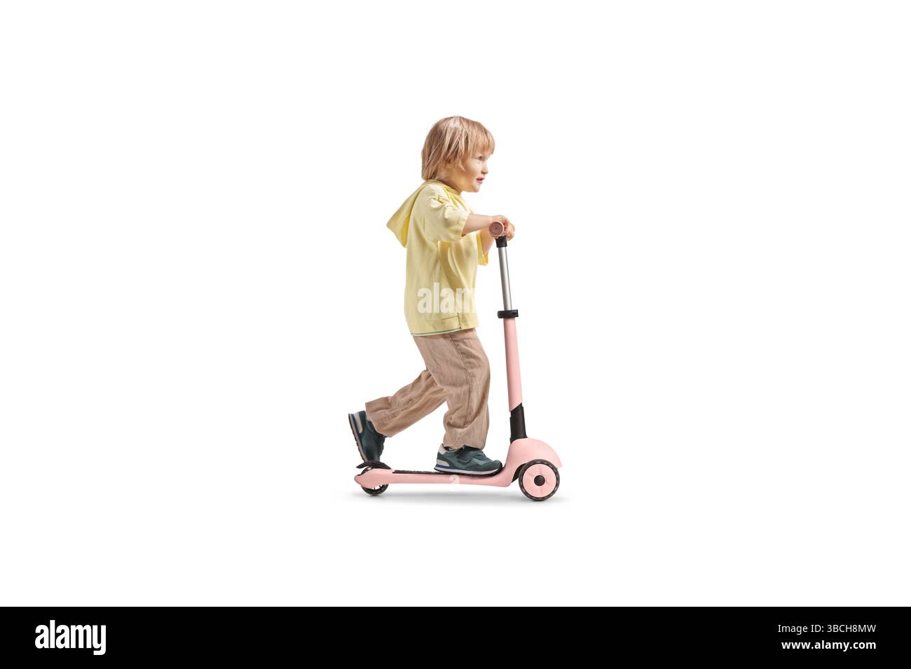 Junge, der einen Roller für Kinder fährt, isoliert auf weißem Hintergrund Stockfoto