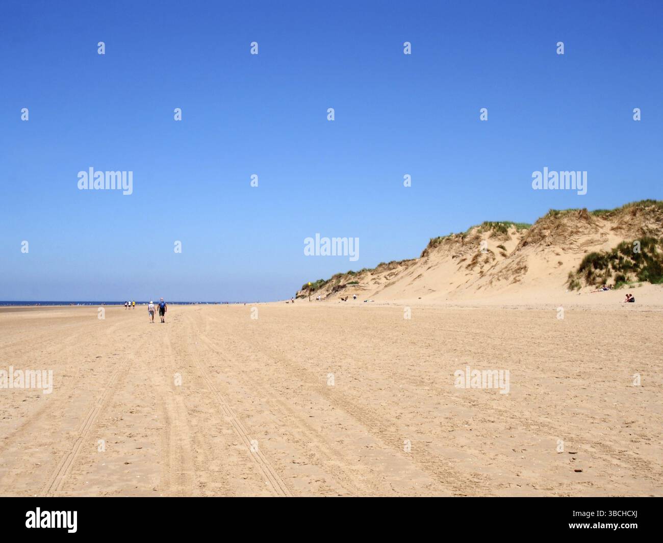 Sefton, merseyside, vereinigtes Königreich, 27. juni 2019: Menschen, die am Strand mit Gras auf den hohen Sanddünen an der Küste von sefton in Merseysi spazieren Stockfoto