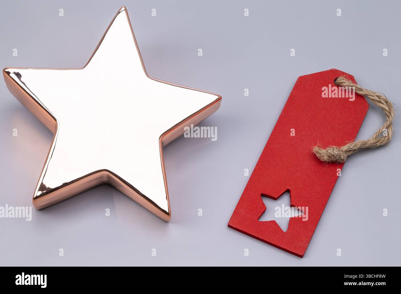 Das Foto zeigt einen goldenen Stern mit einem roten Schild auf einem grauen/grünen Hintergrund Stockfoto