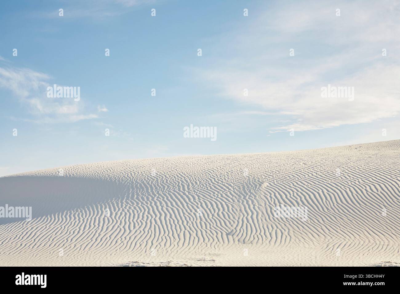 Weiße Sanddünen mit weitläufigen Wolkenmustern am klaren blauen Himmel. Roadtrip USA Stockfoto