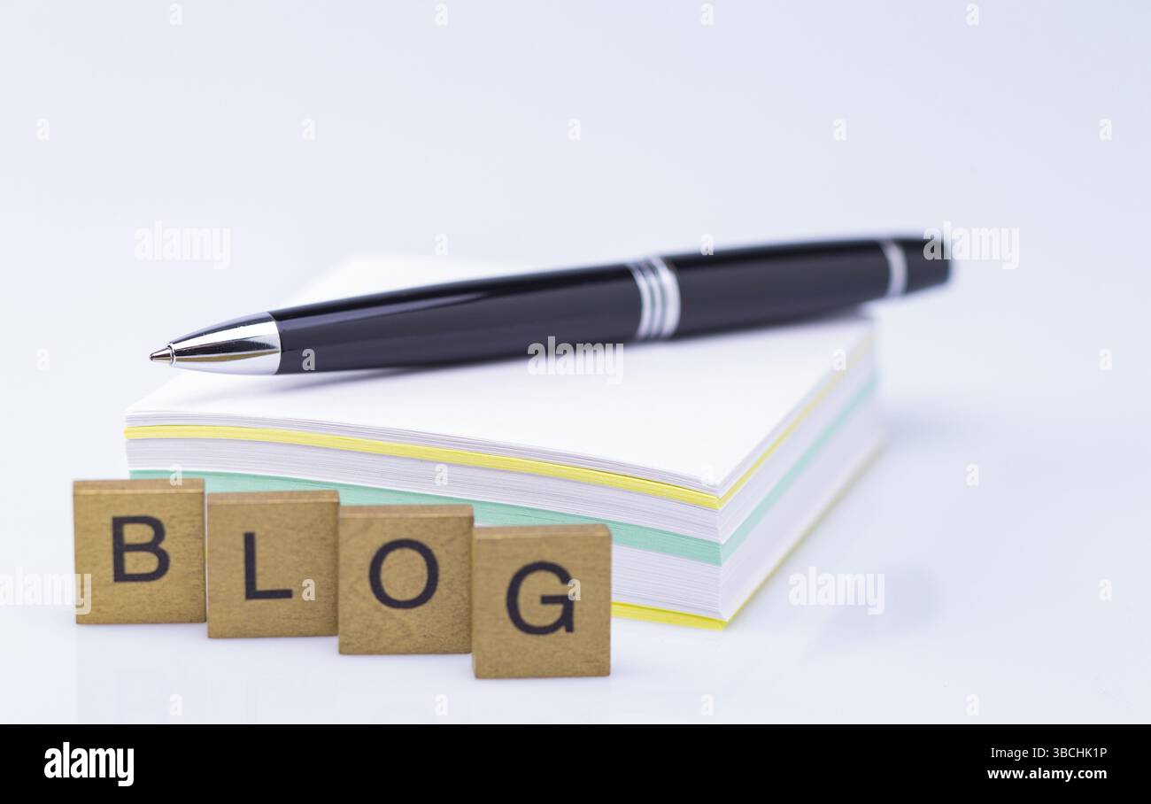 Das Foto zeigt einen Stapel Papier mit einem biro und dem Wort Blog Stockfoto