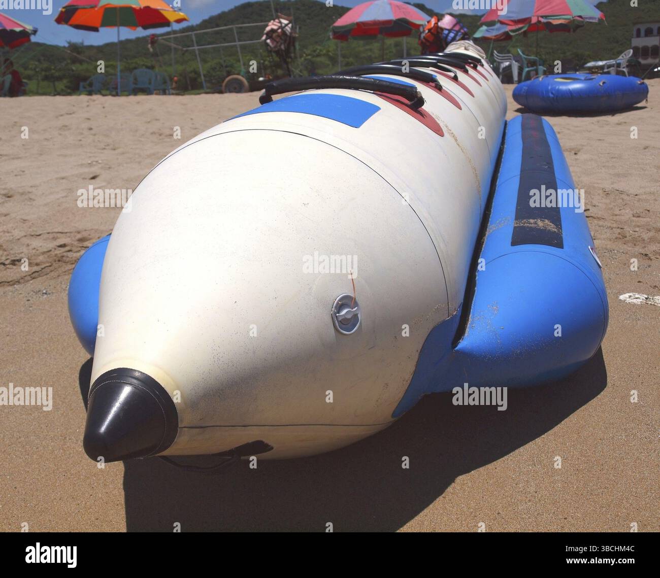 Ein langes Bananenboot ruht auf einem Sandstrand Stockfoto