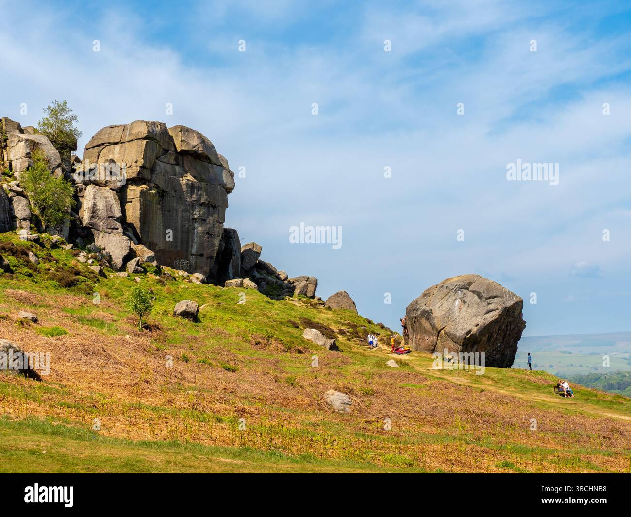 Kletterer am Fuße des Kalbs, dem kleineren Felsen der Kuh- und Kalbformation auf Ilkley Moor, West Yorkshire. UK Stockfoto