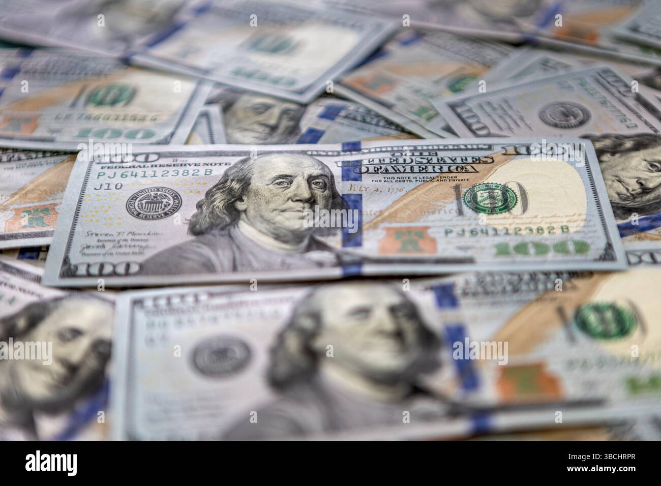 Haufen von 100-Dollar-Banknoten, wobei eine einzelne Rechnung hervorgehoben ist Stockfoto